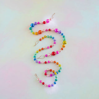a colorful beaded necklace on a white surface