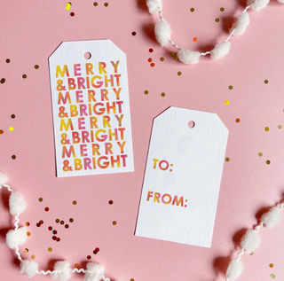 a white tag with yellow text and white beads on a pink surface