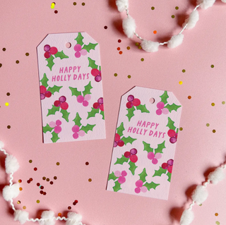 a pink gift tags with holly leaves and berries on it