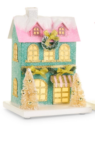a small house with a wreath and trees