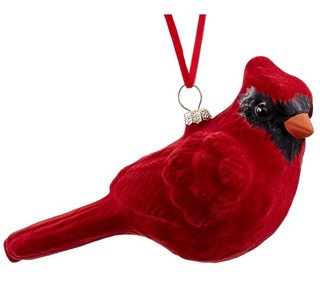 a red bird ornament on a ribbon