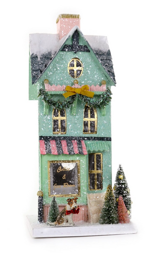 a small house with trees and a couple of santa claus