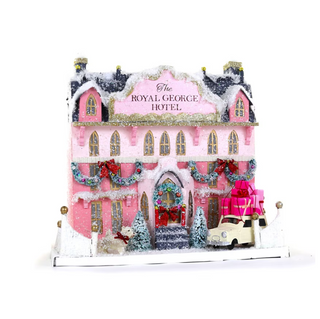 a pink and white building with a car and a truck