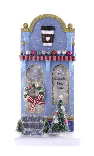 a small blue building with a coffee cup and christmas trees