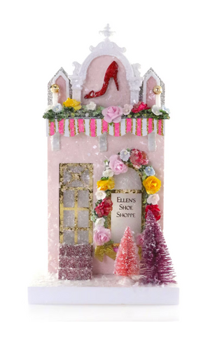 a pink house with flowers and trees