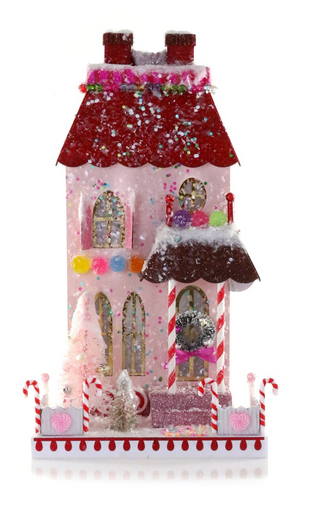 a pink house with candy canes and a tree