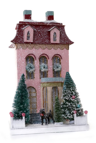 a pink house with trees and horses