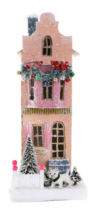 a pink house with a garland and a tree