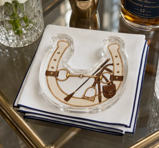a glass plate with a horseshoe and a bottle of whiskey on top of it